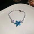 Dettaglio del bracciale argento con fiore di zircone blu su vassoio di ceramica - Bracciale a Fiore / Argento-Blu