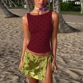 Detail view of red polka dot sleeveless top paired with a green sequin side tie slit skirt - S / Burgundy