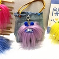 Close-up of a purple fuzzy monster plush keychain with jagged teeth on a denim bag - Single Piece / Purple