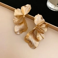 Macro shot showing the brushed metal texture of large golden flower petal earrings - Gold Flower Studs / Gold