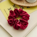 Elegant wine red satin scrunchie with silk luster on a minimal display tray - Burgundy