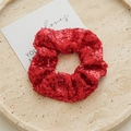 Detalle de un coletero de lentejuelas rojas en un plato de piedra con brillo festivo - Rojo con lentejuelas
