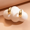 Macro shot of thick gold teardrop C-shape earrings with a polished glossy finish - Stainless Steel Pin - Gold Teardrop
