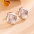 Macro shot of silver square stud earrings featuring a brushed metallic industrial texture - Silver Brushed Square Stud Earrings (H205)