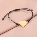 Macro detail of gold heart pendant on black braided rope bracelet with silk texture - 18K Gold (MP145)