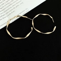 Flat lay of twisted gold hoop earrings on black velvet with artistic paper accent - Silver Earring Post Style / 4cm / Gold
