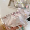 Close-up of pink floral jacquard fabric mini pouch with white zipper and metal handle - Elegant Peony