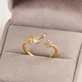 Bague ouverte fleur dorée avec zircons violets et blancs étincelants dans son écrin - Or / Style Branche de Fleur Violette (Style 11)