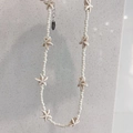 Close-up of handmade beaded necklace with starfish charms and adjustable silver clasp - Off-white Beads + Off-white Starfish Necklace