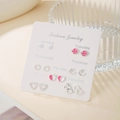 Set of seven pairs of silver stud earrings with pearls and moons on a branded card - Pink Planet Star Moon Style (E1983-1)