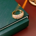 Makroaufnahme von 18K vergoldetem Zirkonia-Ring mit rosa Steinen in grüner Box - Gold