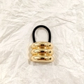 Golden hollow three-ring metal ponytail holder with black elastic band on paper - Gold Triple Bar Smooth 4cm