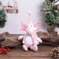 Dettaglio di renna di peluche rosa con paillettes e maglione seduta su ceppo di legno - Bambola da Seduta Rosa Renna