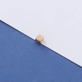 Vue macro d'une perle carrée dorée polie pour la création de bijoux DIY - Or rose