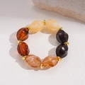 Macro view of vintage amber resin beaded necklace with golden spacer beads on a textured surface - Bracelet / Brown