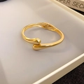 Détail d'un bracelet jonc doré minimaliste à charnière avec finitions brillantes - Style Goutte d'Eau Doré (1#)