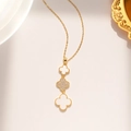 Detail of gold necklace with white clover pendants and central diamond inlay on beige background - White Shell Clover Style (885) / Gold