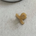 Detailed close-up of a cream-colored acetate mini hair claw clip on a textured surface - Light Coffee (Mini Cross)