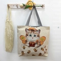 Off-white canvas tote bag featuring cute bee-cat illustration and striped handles - Honey Cat