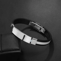 Close-up of black silicone men's bracelet with polished stainless steel clasp on a gift box - White