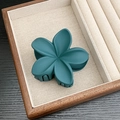 Matte dark green flower hair claw clip with five-petal design on a wooden tray - Matte Five-Petal Flower / Lake Blue