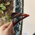 Detail of an 8cm triangular claw clip with amber tortoiseshell texture and resin finish - 8cm / Matte Red Brown