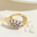 Adjustable golden evil eye ring featuring purple white enamel and a blue center stone - Purple