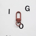 Macro view of a reddish-brown lacquered metal swivel lobster clasp with a D-ring and hook - Coffee