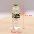 Macro detail of miniature water bottle model with green cap and brand label on wood - Mineral Water 2