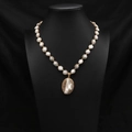 Vintage baroque pearl necklace with large irregular pendant on black mannequin bust - Gold Edged Baroque