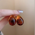Detail of amber teardrop earring with gold-plated metal setting held by hand - 40# Silver Earring Post - Coffee Teardrop