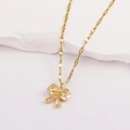 Gros plan détaillé d'un pendentif papillon plaqué or avec des pierres de zircone cubique - Style 7-Noeud Papillon Luxueux Doré