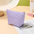 Portable large purple cosmetic bag with quilted diamond pattern in a travel lifestyle setting - Trapezoid Bag / Light Purple