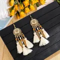 Detail of bohemian tassel earrings with gold floral charms and white cotton fringe - Seed Bead White Tassel (H3675)
