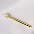 Gedetailleerde close-up van gouden metalen balpen met een doorschijnende kristallen edelsteen - Bergkristal