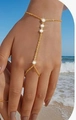 Bracciale ad anello dorato con pietre tonde bianche indossato sulla spiaggia - Trapani collegati dorati