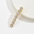 Nahaufnahme der goldenen Haarspange mit sieben funkelnden Strass-Sonnenblumenmotiven - Gold