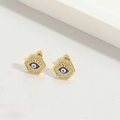 Détail de boucles d'oreilles hexagonales dorées avec œil grec bleu et zircons fins - Style Hexagonal / Œil Bleu Roi