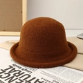 Detailed texture of a dark brown wool felt bucket hat with retro rolled brim design - Camel