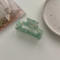 Detail of a rectangular acetate hair claw clip with green marble texture and hollow design - Large Square Claw / Light Green