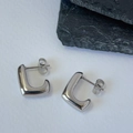 Detailed macro view of silver L-shaped geometric earrings with polished mirror finish - Silver