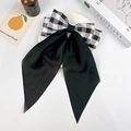 Dettaglio del fiocco in raso nero con motivo scozzese grigio-rosa su sfondo bianco - Nero