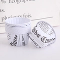 Stack of white cupcake liners with black newspaper print pattern for professional baking - English Newspaper Print