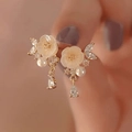 Close-up of golden floral earrings with white pearls and sparkling crystal details - Gold Pearl Rhinestone Flower Studs