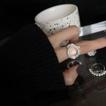 Adjustable silver ring with irregular texture and round clear gemstone on a hand - No. 44 Open Ring