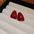 Primer plano de pendientes de esmalte rojo oscuro con borde dorado en caja de joyas - Pendientes de Botón de Esmalte en Forma de Gota (7#)