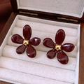 Gros plan détaillé de boucles d'oreilles fleurs en résine bordeaux dans un écrin en bois - Rouge (Tige de boucle d'oreille en argent sterling 925)