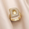 Gold plated ring featuring letter D design with zircon pavé on beige silk background - Small / Letter D
