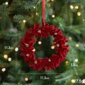 Red velvet Christmas wreath ornament with gold accents on festive tree branch - Red Flocked Wreath