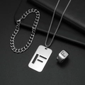 Makroaufnahme von silbernem Edelstahl-Schmuckset mit F-Gravur auf schwarzem Hintergrund - Set F